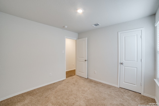 unfurnished bedroom featuring light carpet