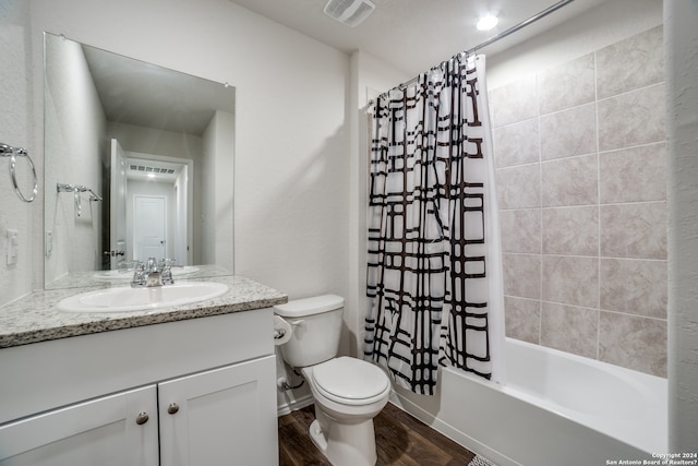 full bathroom featuring hardwood / wood-style floors, toilet, shower / bath combo with shower curtain, and vanity with extensive cabinet space