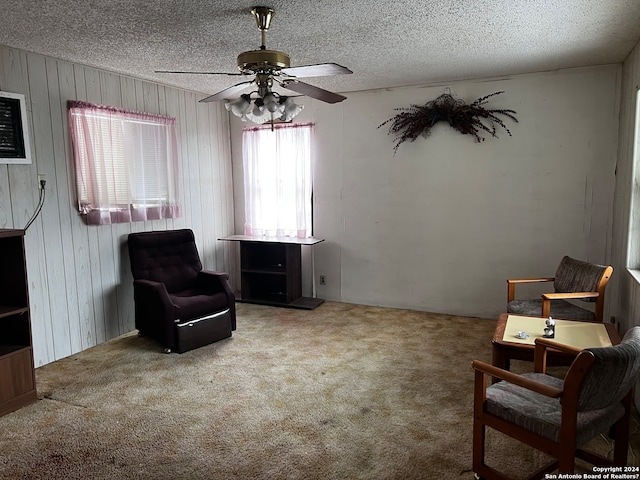 sitting room with carpet, ceiling fan, and a textured ceiling