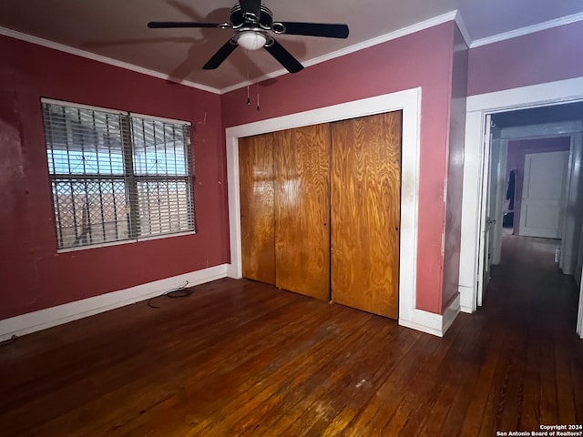 unfurnished bedroom with ceiling fan, dark wood-type flooring, ornamental molding, and a closet