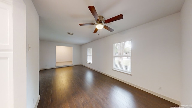 unfurnished room with ceiling fan and dark wood-type flooring