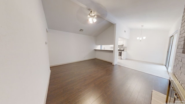 unfurnished living room with vaulted ceiling, a wealth of natural light, ceiling fan with notable chandelier, dark hardwood / wood-style flooring, and sink