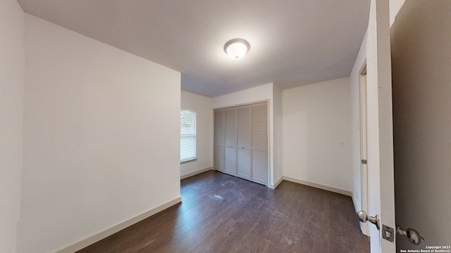 empty room with dark hardwood / wood-style flooring