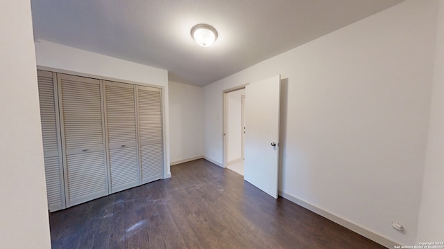 unfurnished bedroom featuring a closet and dark hardwood / wood-style flooring