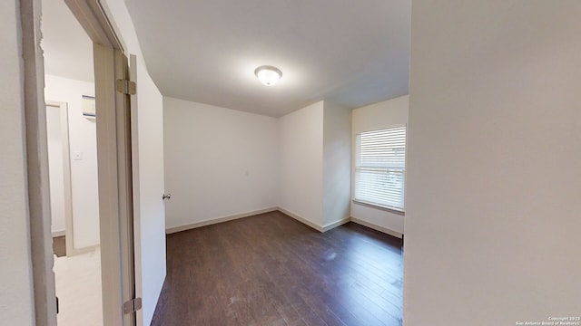 empty room with dark hardwood / wood-style flooring and a wall mounted AC