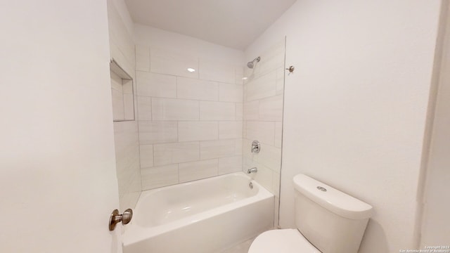 bathroom with toilet and tiled shower / bath