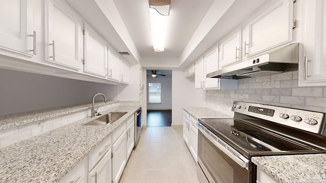 kitchen featuring light stone countertops, white cabinetry, ceiling fan, appliances with stainless steel finishes, and sink