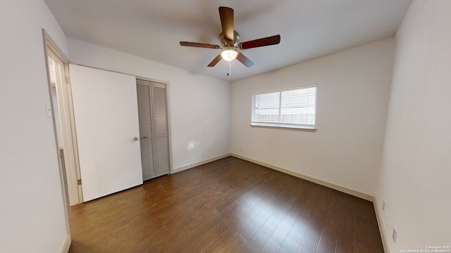 unfurnished bedroom with dark hardwood / wood-style flooring, ceiling fan, and a closet