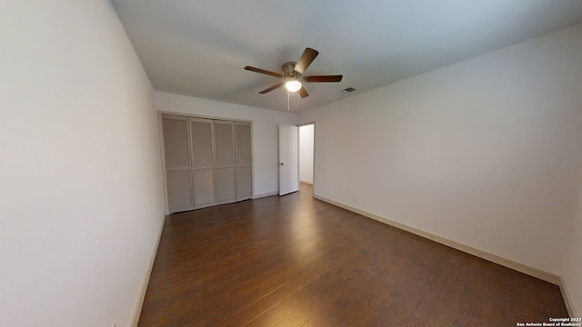 empty room featuring dark hardwood / wood-style flooring and ceiling fan