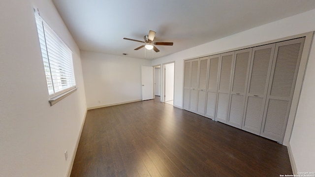 unfurnished bedroom with a closet, dark hardwood / wood-style floors, and ceiling fan