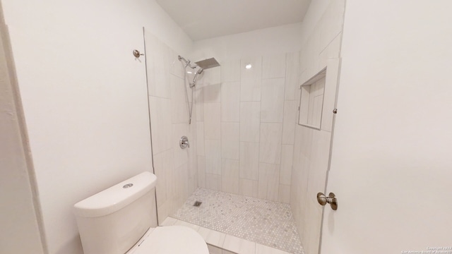 bathroom with toilet and tiled shower