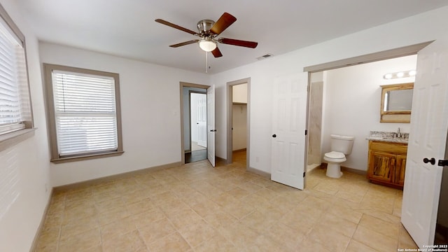 unfurnished bedroom with ensuite bath, light tile floors, ceiling fan, a closet, and sink