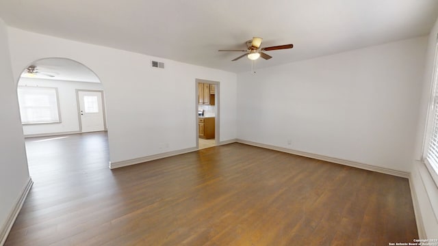 empty room featuring ceiling fan and dark wood-type flooring