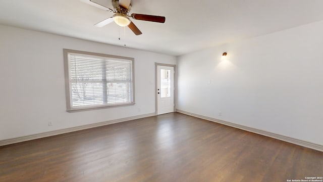 empty room with ceiling fan and dark hardwood / wood-style flooring