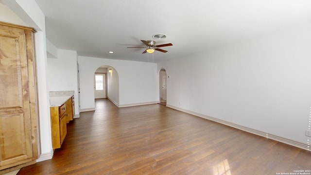 empty room with ceiling fan and dark wood-type flooring