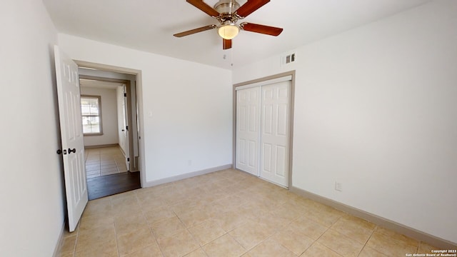 unfurnished bedroom featuring light tile flooring, a closet, and ceiling fan