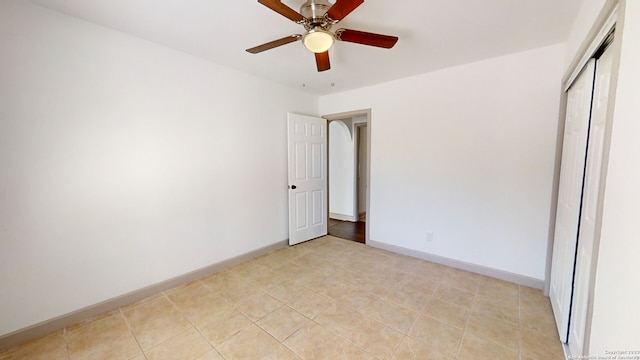 tiled empty room with ceiling fan