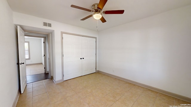 unfurnished bedroom featuring ceiling fan, light tile floors, and a closet