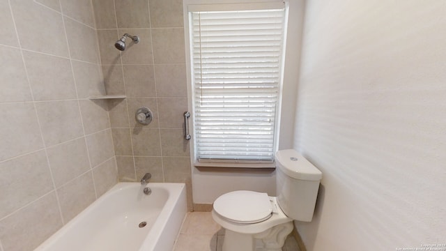 bathroom with tiled shower / bath combo, tile floors, toilet, and a healthy amount of sunlight