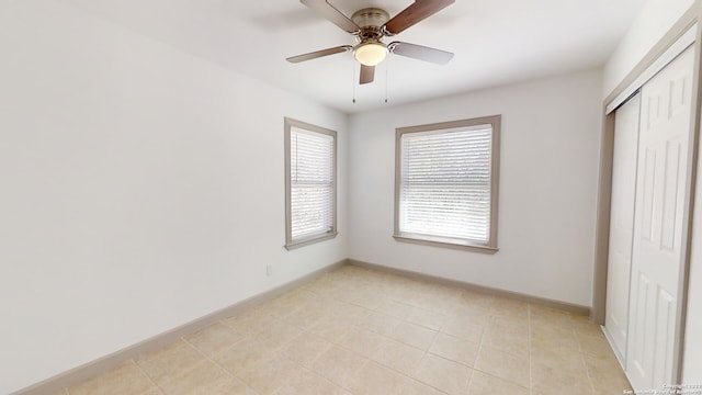 unfurnished bedroom featuring ceiling fan, a closet, and light tile floors