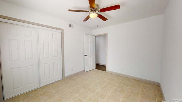 unfurnished bedroom featuring light tile flooring, a closet, and ceiling fan