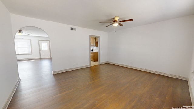 empty room featuring ceiling fan and dark wood-type flooring