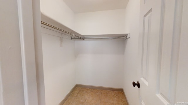 spacious closet with light tile floors