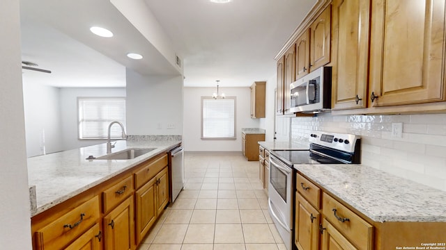 kitchen with hanging light fixtures, stainless steel appliances, backsplash, a notable chandelier, and sink