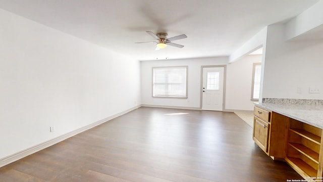 unfurnished living room with ceiling fan and dark hardwood / wood-style floors