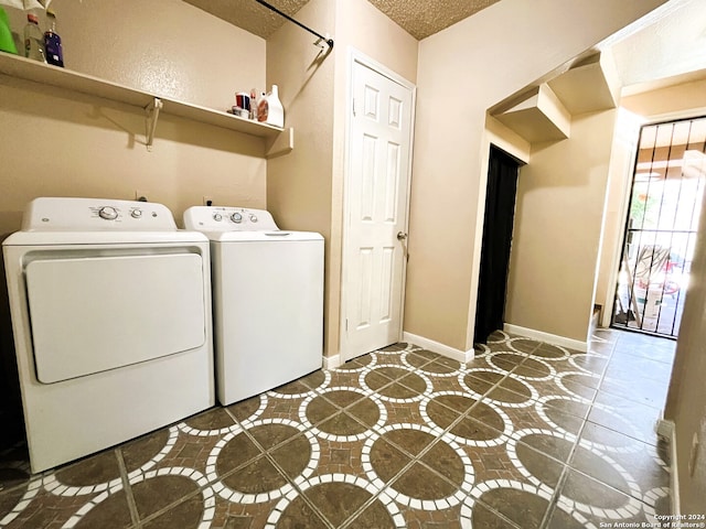 laundry room with dark tile floors and washer and clothes dryer