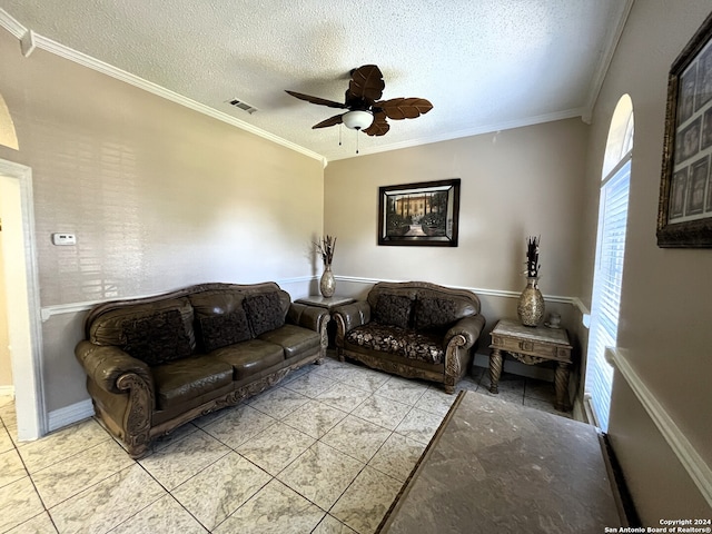 living room with light tile floors, a textured ceiling, ceiling fan, and ornamental molding