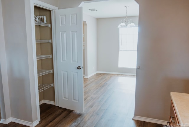 hall featuring dark hardwood / wood-style flooring and an inviting chandelier