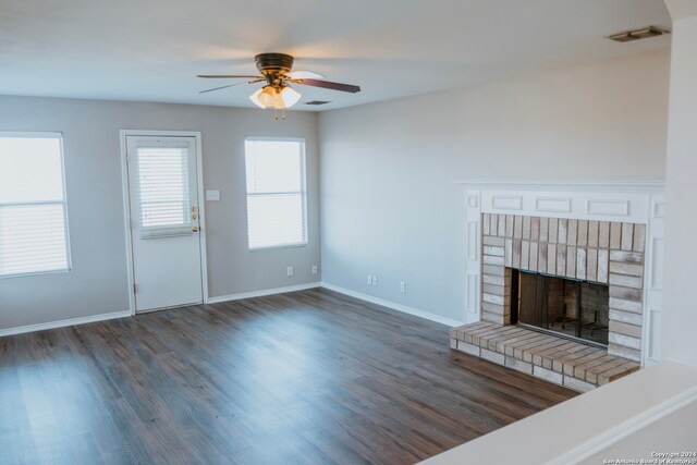 unfurnished living room featuring ceiling fan, dark hardwood / wood-style flooring, and a fireplace