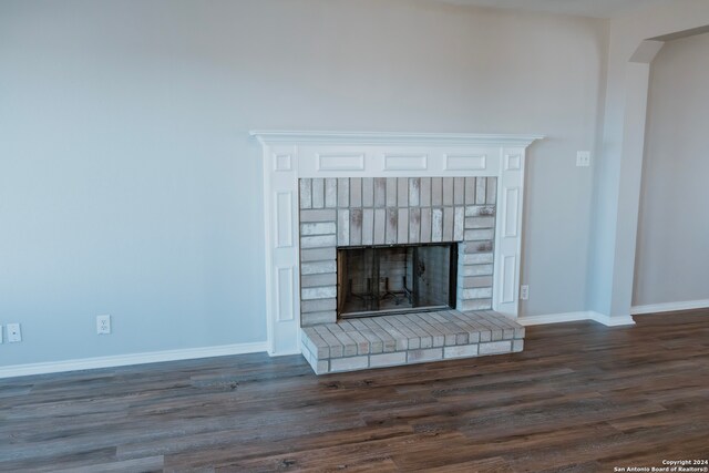 details with dark hardwood / wood-style flooring and a brick fireplace