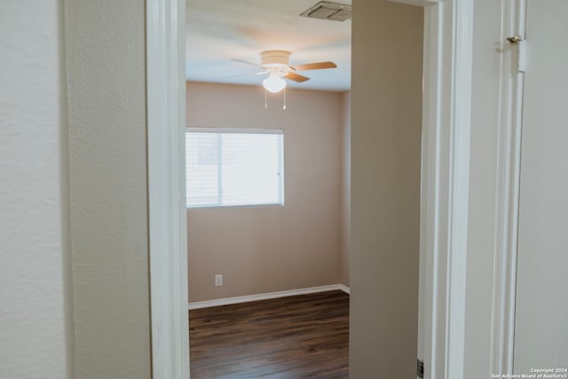 empty room with dark hardwood / wood-style flooring and ceiling fan