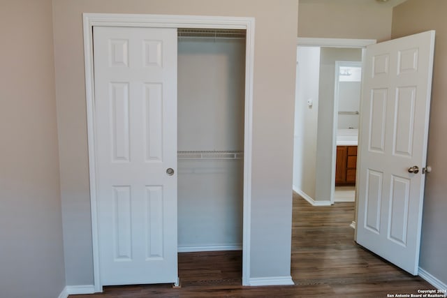 unfurnished bedroom with dark hardwood / wood-style flooring and a closet