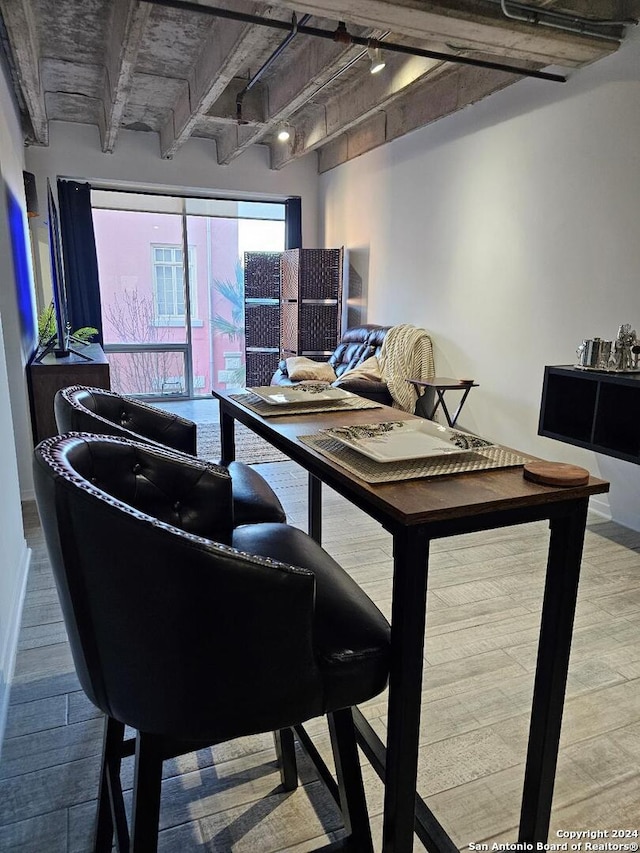 office area with track lighting, light wood-type flooring, and beamed ceiling