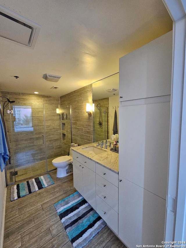 bathroom with toilet, walk in shower, and vanity