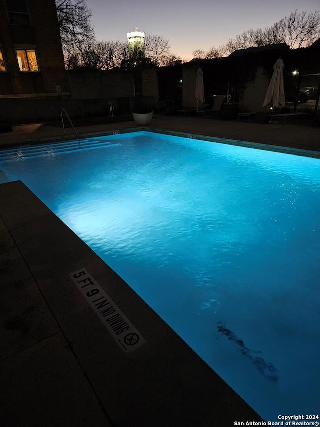 view of pool at dusk