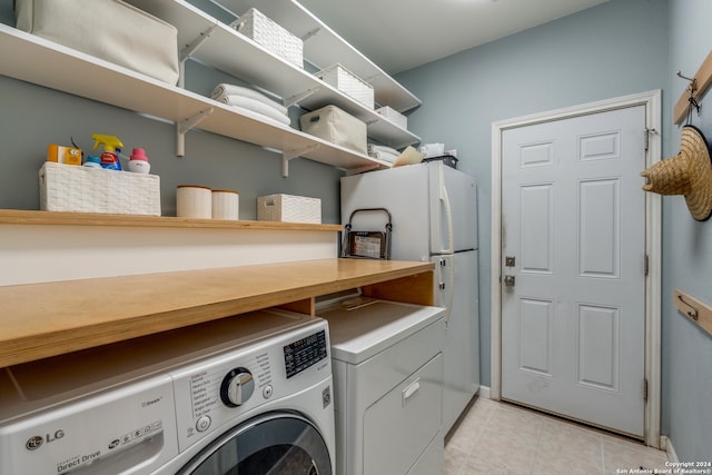 washroom with washer and clothes dryer and light tile floors