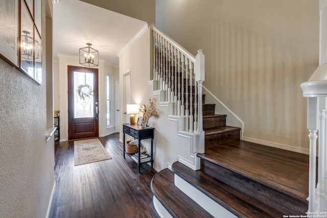 foyer featuring crown molding, dark wood-type flooring, and a chandelier