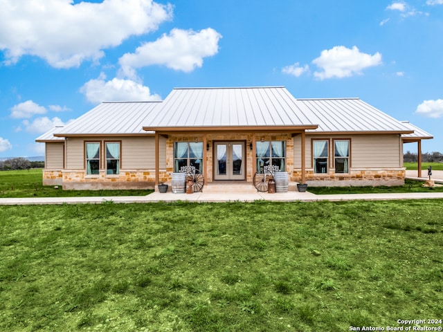 rear view of property with a lawn and french doors