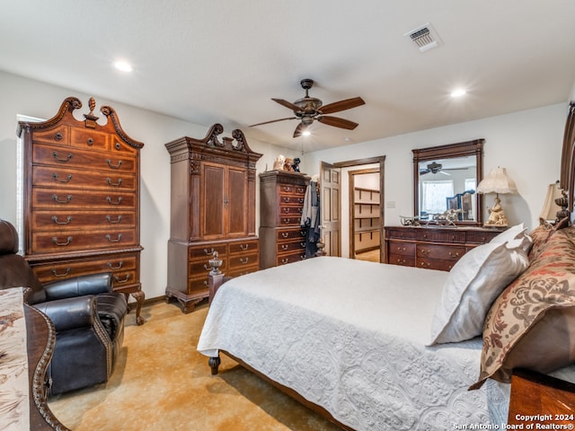 bedroom with light carpet, a spacious closet, and ceiling fan