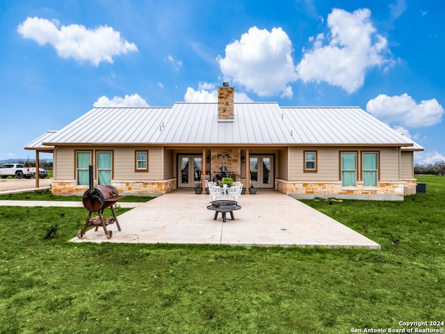 back of property featuring a lawn, a patio area, and french doors