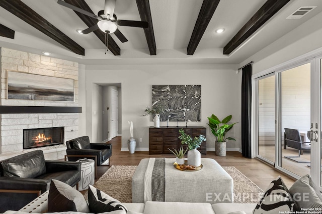 living room with a fireplace, beam ceiling, light hardwood / wood-style floors, and ceiling fan