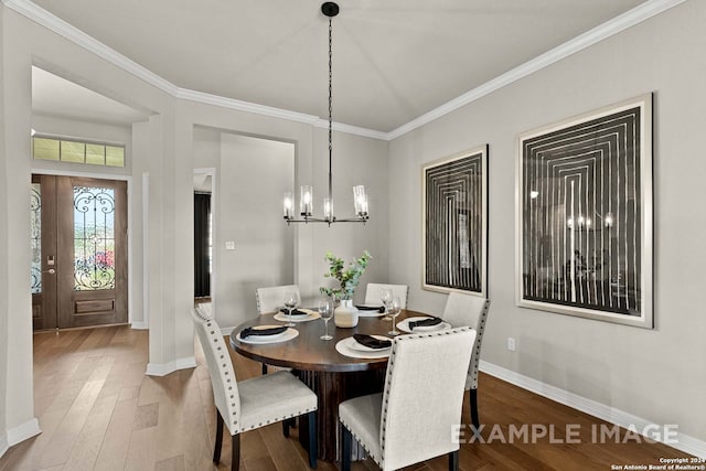 dining space featuring a notable chandelier, ornamental molding, and hardwood / wood-style floors