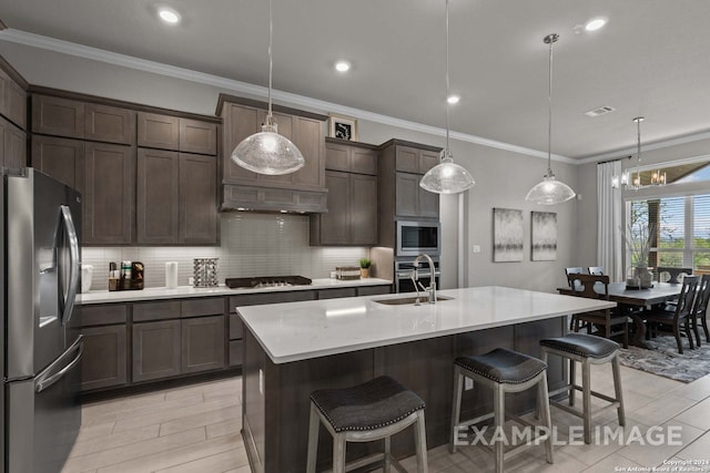 kitchen featuring an island with sink, pendant lighting, backsplash, stainless steel appliances, and a notable chandelier