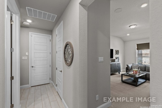 hallway with light colored carpet