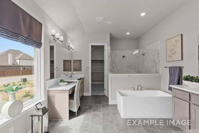 bathroom with a washtub, tile floors, and large vanity