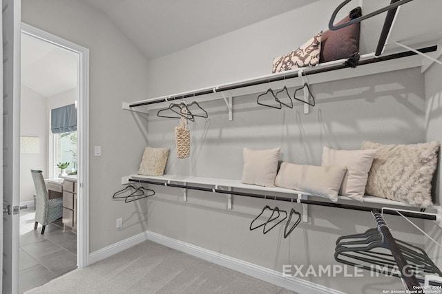 spacious closet featuring vaulted ceiling and light tile floors